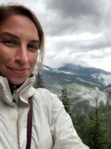 Lauren Surovi in a selfie with the Dolomites and clouds in the background
